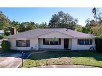 White brick ranch house with a dark brown roof and landscaped lawn at 4510 W Mcelroy Ave, Tampa, FL 33611