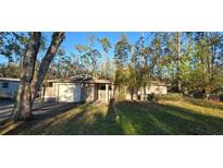 Cozy single-story home featuring a front yard, attached garage, and neutral paint scheme at 6906 Quail Hollow Blvd, Wesley Chapel, FL 33544