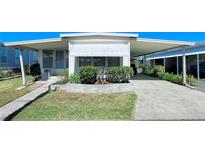 Single-wide manufactured home with carport and landscaped front yard at 18675 Us Highway 19 N # 232, Clearwater, FL 33764