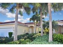 Exterior view of a charming villa with lush landscaping and a two-car garage at 311 Monaco Dr # 4, Punta Gorda, FL 33950