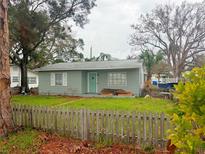 Ranch-style house with a green exterior, picket fence, and a yard at 7209 Park S St, St Petersburg, FL 33707