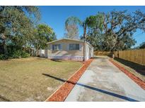 Single-wide mobile home with a paved driveway and landscaped yard at 9532 Lake Dr, New Port Richey, FL 34654