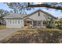 Charming single story home with a screened porch and well-manicured lawn at 1321 Riverside Dr, Tarpon Springs, FL 34689