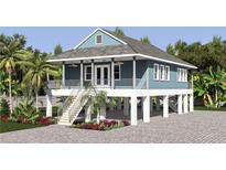 Charming elevated home with light blue exterior and spacious deck at 1840 Douglas Ave, Dunedin, FL 34698