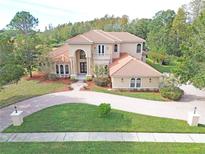 Two-story house with circular driveway and beautiful landscaping at 3050 Wentworth Way, Tarpon Springs, FL 34688