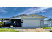 Charming single-story home with a white exterior, attached garage, and a well-maintained lawn at 4501 Helena Ne St, St Petersburg, FL 33703