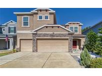 Two-story house with a two-car garage and stone accents at 10439 Waterstone Dr, Riverview, FL 33578