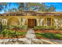 Spanish style home with a lush, manicured lawn and walkway at 1116 N Riverhills Dr, Temple Terrace, FL 33617
