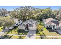 Charming single-story home featuring a well-manicured lawn, mature trees, and a two-car garage at 35608 Welby Ct, Zephyrhills, FL 33541