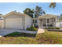 Gray house with attached garage and screened porch at 703 Old Charleston Way, Largo, FL 33770