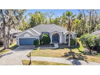 Charming single-story home featuring a lush front yard and attached two car garage at 12306 Woodlands Cir, Dade City, FL 33525
