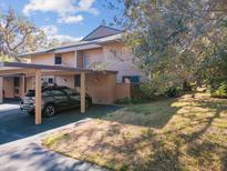 Exterior view of condo with carport, landscaping, and a spacious lawn at 1901 Lennox E Rd # 1901, Palm Harbor, FL 34683