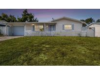 Charming one-story home with a neatly manicured lawn and classic white picket fence at 3529 Windham Dr, Holiday, FL 34691