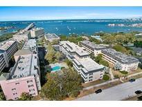 Beautiful aerial view of a waterfront apartment community with lush landscaping and a pool at 147 Bluff View Dr # 204, Belleair Bluffs, FL 33770