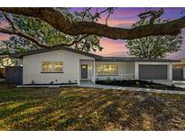 Updated single story home with gray accents and a large oak tree at 523 Deville E Dr, Largo, FL 33771