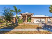 Brick home with a three-car garage and palm trees at 937 Bunker View Dr, Apollo Beach, FL 33572