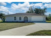 Single story home with attached garage and landscaped lawn at 11339 Gulfstream Blvd, Port Charlotte, FL 33981