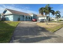 Spacious home with a large driveway and palm trees in front at 2161 Aqui Esta Dr, Punta Gorda, FL 33950