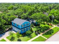 Stunning aerial view of a charming two-story blue house with a large yard and mature trees at 509 N Glenwood Ave, Clearwater, FL 33755