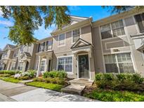 Two-story townhome with light-colored siding, landscaping, and a welcoming front porch at 10334 Estero Bay Ln, Tampa, FL 33625