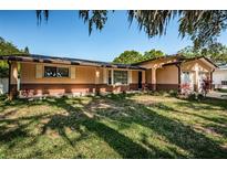 Brick ranch home with a large yard and mature trees at 1201 Kapok Cir, Clearwater, FL 33759