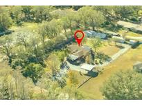 Aerial view of a house and surrounding property with trees and a driveway at 5201 Pless Rd, Plant City, FL 33565
