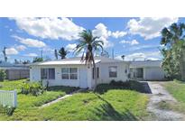 Front view of a charming single-story home with a spacious yard at 14140 E Parsley Dr, Madeira Beach, FL 33708