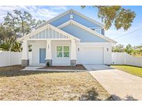 Two-story light blue house with white trim, a white garage door, and a covered porch at 3005 E 17Th Ave, Tampa, FL 33605