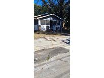 Cozy gray house with screened porch, needing driveway repair at 3204 E 23Rd Ave, Tampa, FL 33605