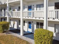 Condo building exterior showcasing individual unit entrances and well-maintained landscaping at 350 79Th N Ave # 108, St Petersburg, FL 33702