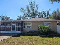 Tan single story house with screened porch and landscaped yard at 3914 W Gray St, Tampa, FL 33609