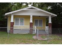 Yellow bungalow with front porch and brick columns at 8216 N 14Th St, Tampa, FL 33604