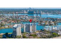 Aerial view of waterfront condo building with parking and boat slips at 9415 Blind Pass Rd # 601, St Pete Beach, FL 33706