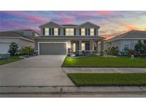 Two-story house with a large front yard, two-car garage, and neutral color scheme at 10507 Daybreak Gln, Parrish, FL 34219