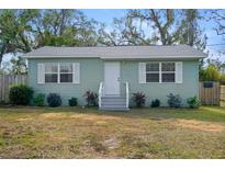 Charming light green house with white trim and a white front door at 37044 Florida Ave, Dade City, FL 33525