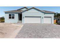 Charming light blue home featuring a spacious two-car garage and a stylish paved driveway at 3430 Sarto Ln, Rotonda West, FL 33947
