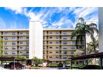 Three-story condo building with parking and lush landscaping at 900 Cove Cay Dr # 2B, Clearwater, FL 33760