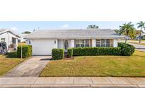 Charming single-story home with a white exterior, attached garage, and landscaped yard at 9201 40Th N Way, Pinellas Park, FL 33782