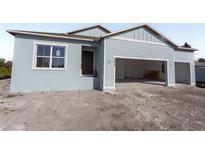 Newly constructed light blue home with a two-car garage at 3430 Sarto Ln, Rotonda West, FL 33947