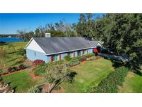 Ranch-style home with blue siding, red shutters, and a spacious lawn at 3111 Lewis Rd, Dover, FL 33527