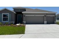Charming single-story home with a manicured lawn and a three car garage at 10725 Tippecanoe Pl, Parrish, FL 34219