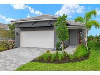 Gray modern home with white garage door, landscaping, and paver driveway at 11182 Livewell Ct, Venice, FL 34293