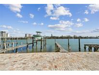 Brick-paved waterfront dock with boat lift and tranquil waterway at 143 94Th Ave # 2, Treasure Island, FL 33706