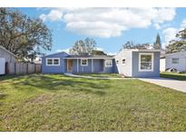 Newly renovated light blue house with a large yard and driveway at 2537 Martha Ln, Land O Lakes, FL 34639