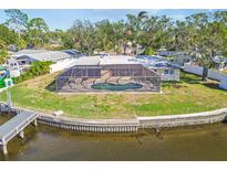 Aerial view of a single-story home with a pool and private dock on a canal at 4780 Butterfly Ne Pl, St Petersburg, FL 33703