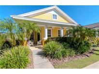 Cute yellow house with a front porch and nicely landscaped yard at 5314 Golden Isles Dr, Apollo Beach, FL 33572