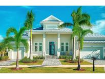Charming two-story home with beautifully landscaped yard, palm trees, and a symmetrical facade at 5713 Tybee Island Dr, Apollo Beach, FL 33572