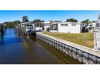 White mobile home on the waterfront with a boat lift at 162 S Saint Thomas Cir, Apollo Beach, FL 33572