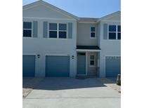 Charming townhome featuring a one-car garage and light blue accents at 4592 Pleasant Ave, Palm Harbor, FL 34683
