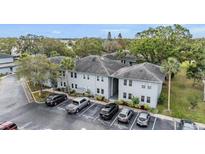 Aerial view of a condo building with parking and lush landscaping at 10800 Us 19 N. # 230, Pinellas Park, FL 33782